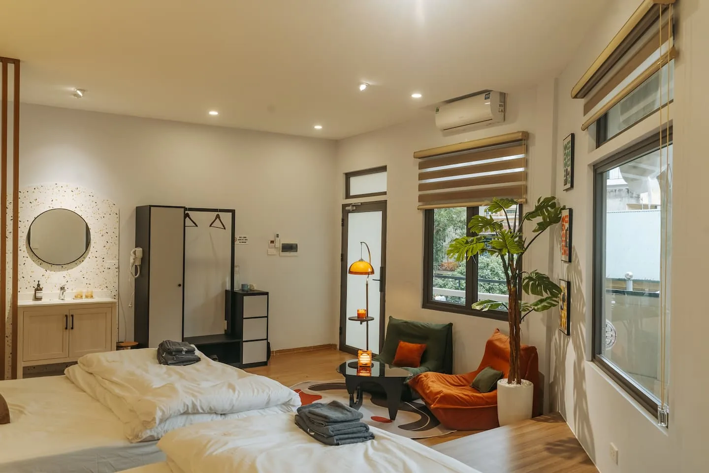 Bedroom 1 — two king beds, a lounge chair and greenery